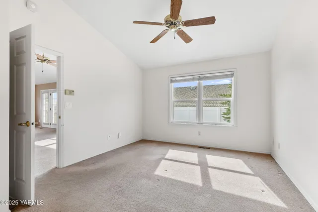 an empty room with a window and a fan