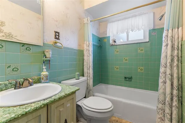 a bathroom with a granite countertop toilet sink and mirror