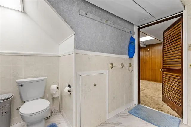 a white toilet sitting next to a bathroom