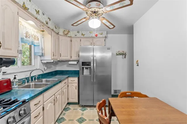 a kitchen with stainless steel appliances granite countertop a sink refrigerator and microwave