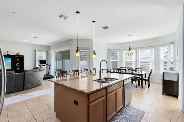a large kitchen with kitchen island a sink table and chairs