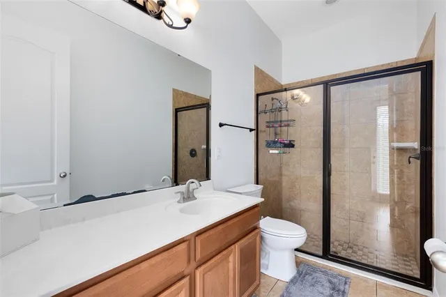 a bathroom with a granite countertop sink toilet a mirror and shower