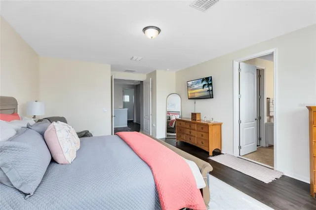 a bedroom with a bed and wooden floor