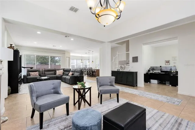 a living room with furniture a dining table and chairs with wooden floor