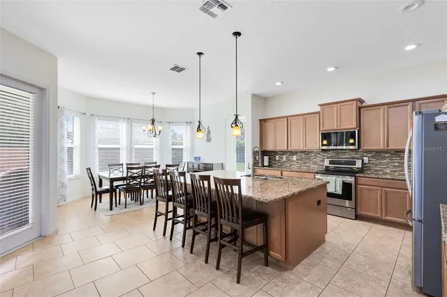 a large kitchen with a table and chairs