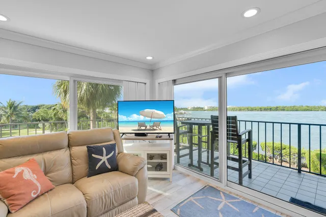 a living room with furniture a floor to ceiling window and stairs