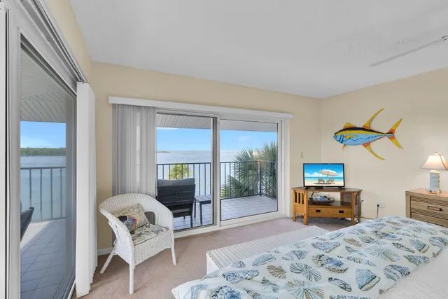 a bedroom with a bed and large windows