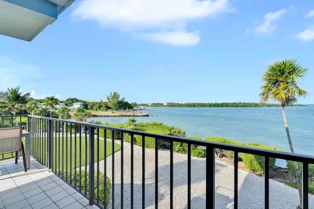 a view of a balcony with wooden floor and a lake view