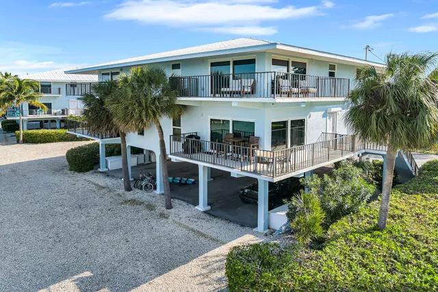 front view of house with a yard and potted plants