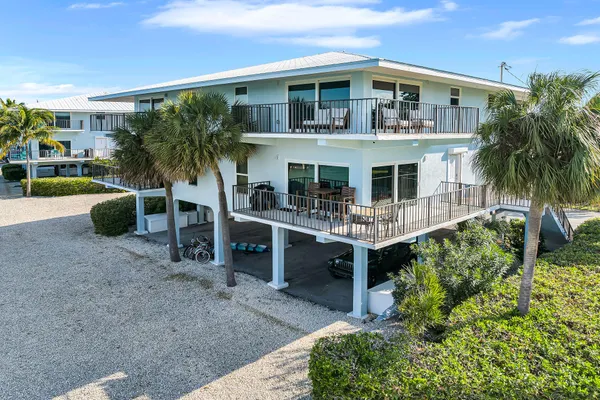 a living room with furniture a floor to ceiling window and stairs