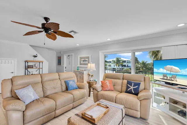 a living room with furniture ceiling fan and a window
