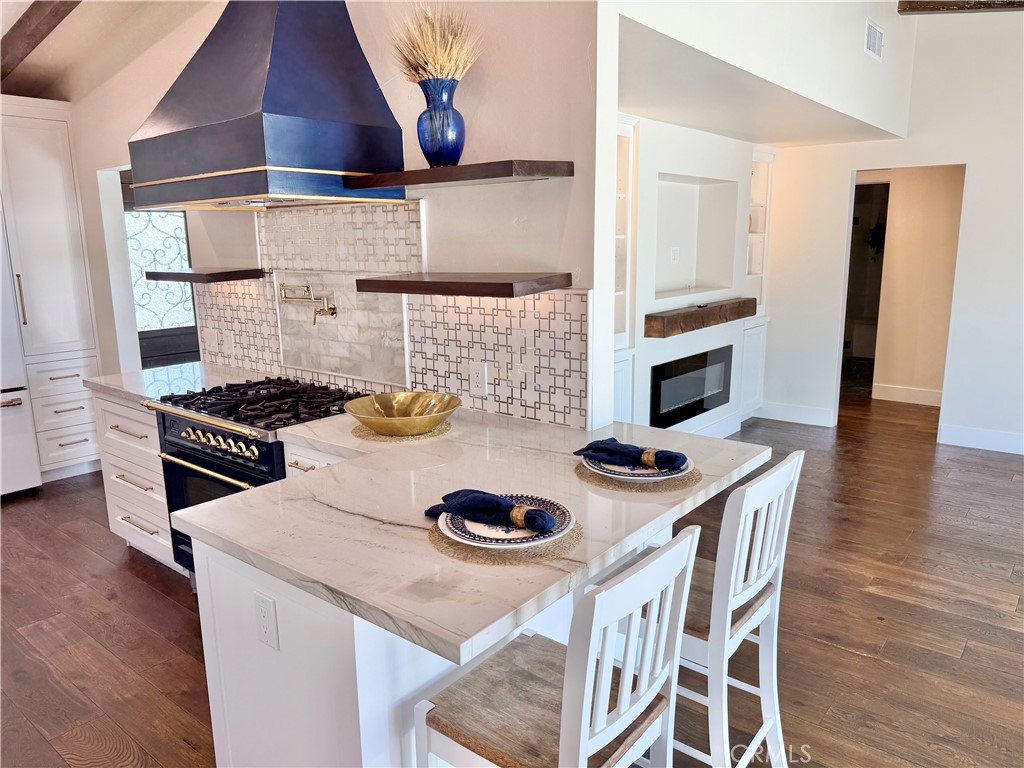 13302 Sandra Place Garden Grove, CA 92843 - Photo 12 of 41 a kitchen with a stove and wooden floor