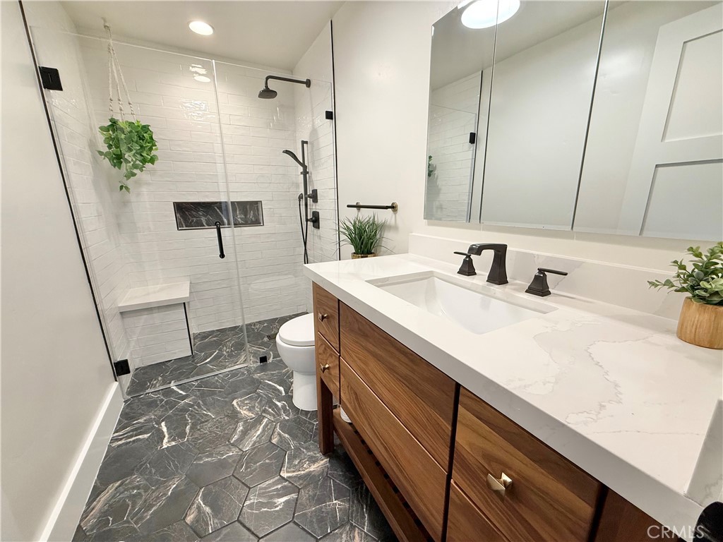 13302 Sandra Place Garden Grove, CA 92843 - Photo 17 of 41 a bathroom with a sink a toilet and a mirror