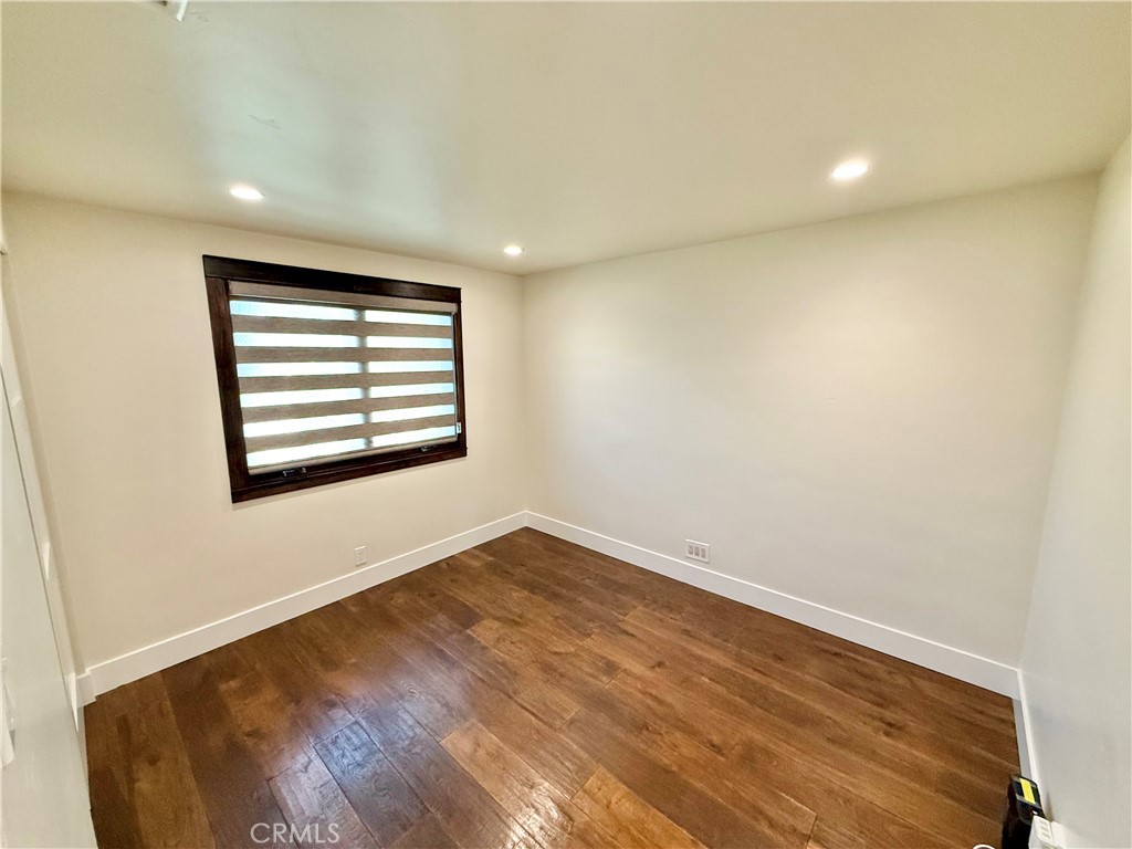 13302 Sandra Place Garden Grove, CA 92843 - Photo 18 of 41 an empty room with wooden floor and windows