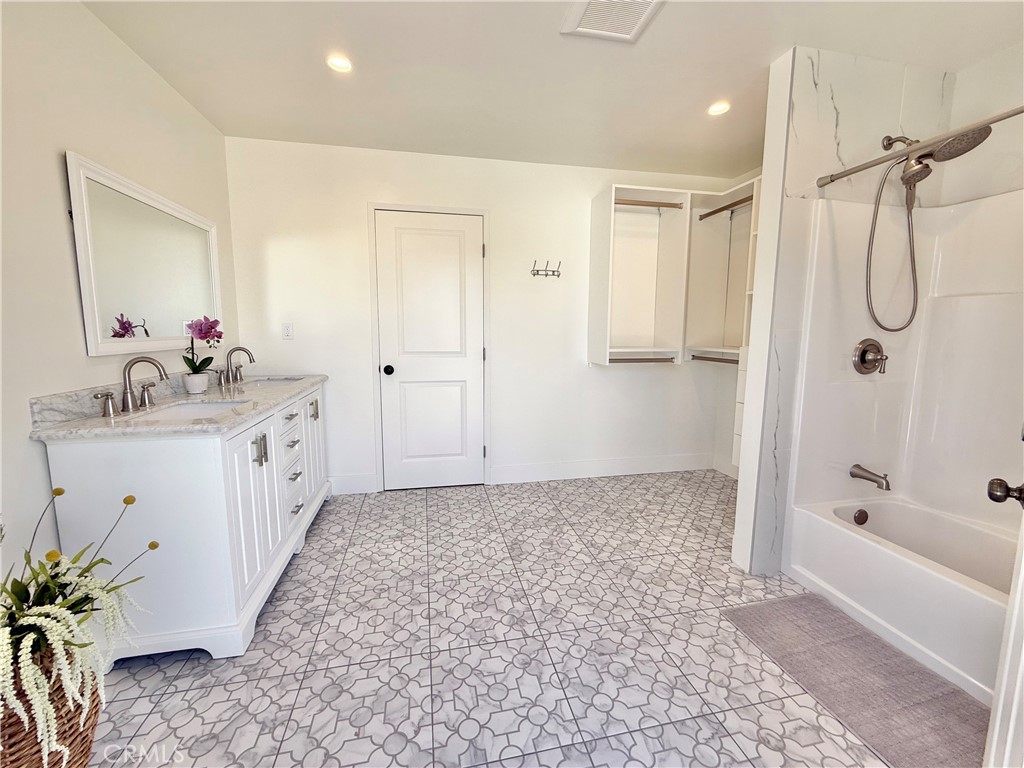 13302 Sandra Place Garden Grove, CA 92843 - Photo 22 of 41 a bathroom with a tub sink and mirror