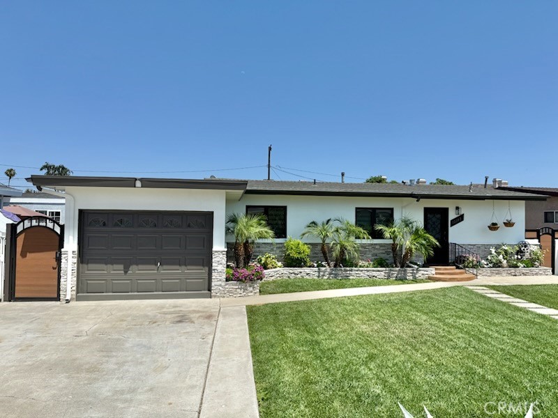 13302 Sandra Place Garden Grove, CA 92843 - Photo 3 of 41 a front view of a house with a yard and garage