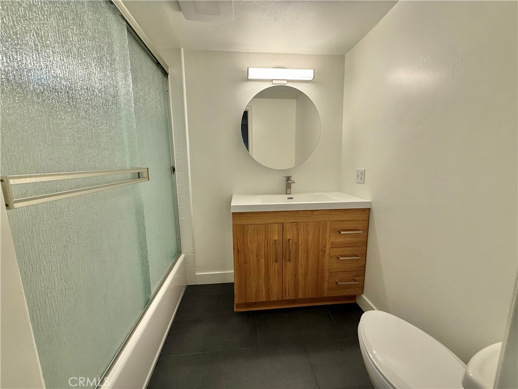13302 Sandra Place Garden Grove, CA 92843 - Photo 40 of 41 a bathroom with a toilet a sink a mirror and vanity