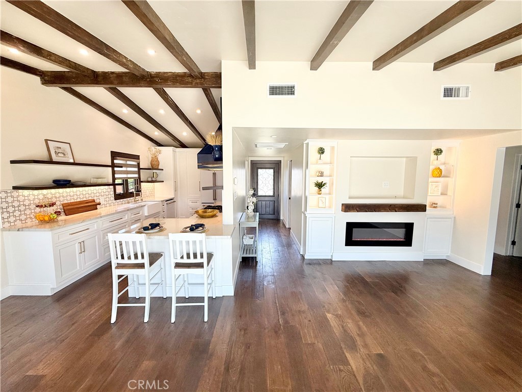 13302 Sandra Place Garden Grove, CA 92843 - Photo 6 of 41 a dining room with furniture wooden floor a painting and a fireplace