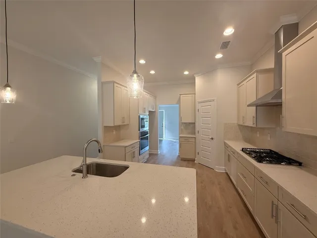 a kitchen with stainless steel appliances a sink a stove a refrigerator and cabinets