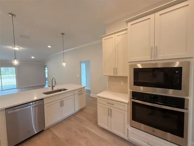 a kitchen with a sink stove and microwave