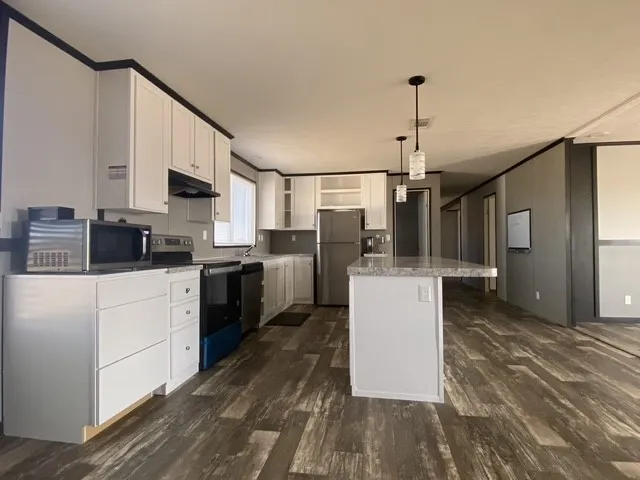 a kitchen with a sink cabinets stainless steel appliances and a counter top space