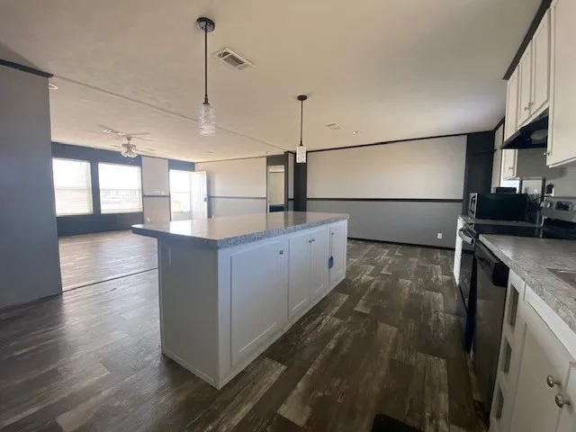 a kitchen with kitchen island a sink appliances and cabinets