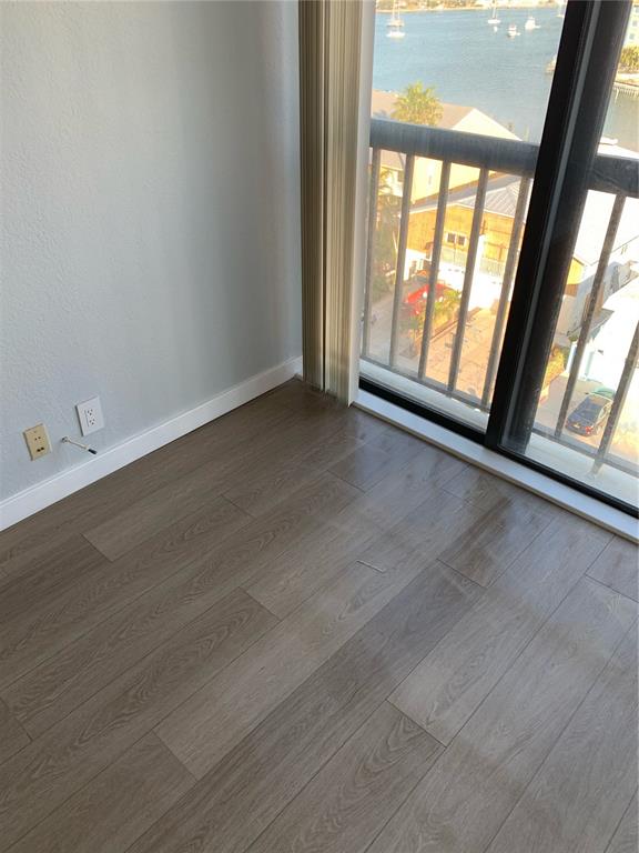 255 Dolphin Point, Unit 809 Clearwater, FL 33767 - Photo 8 of 42 an empty room with wooden floor and windows