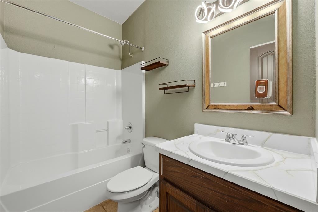 113 Mulkey Road Waxahachie, TX 75167 - Photo 19 of 39 a bathroom with a granite countertop sink toilet and shower
