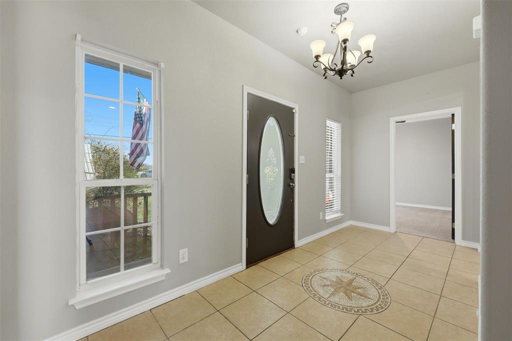 113 Mulkey Road Waxahachie, TX 75167 - Photo 21 of 39 a view of a hallway with wooden floor and chandelier