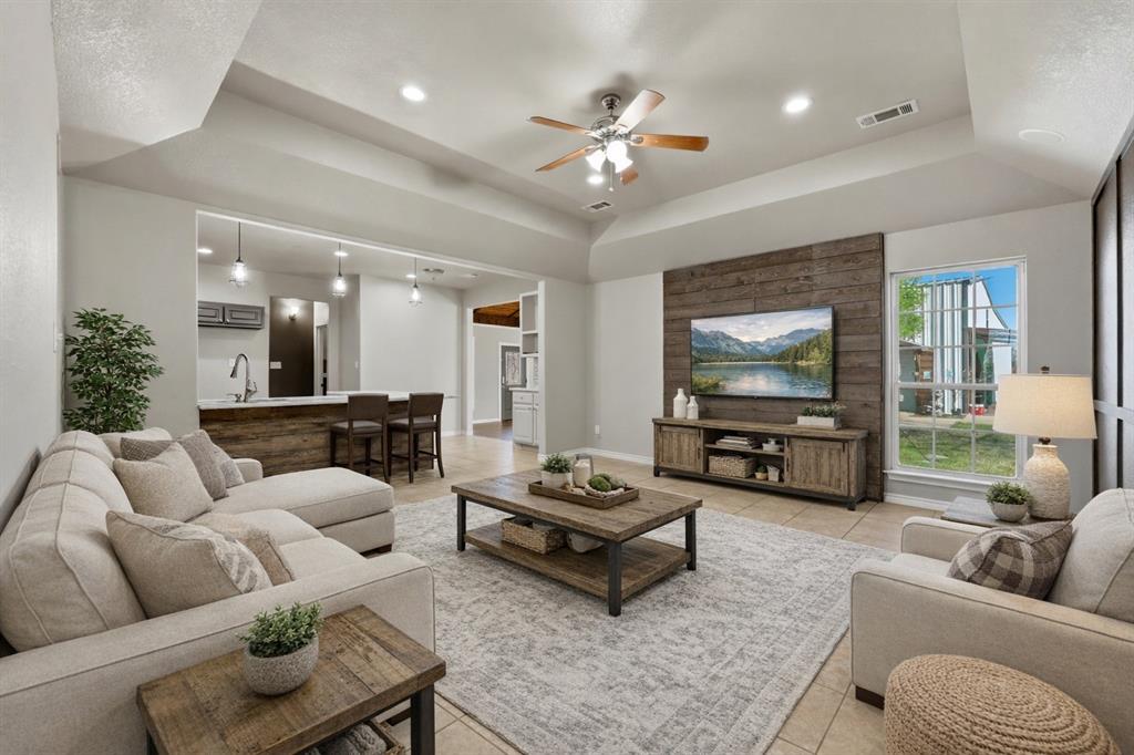 113 Mulkey Road Waxahachie, TX 75167 - Photo 3 of 39 a living room with furniture and a flat screen tv with wooden floor