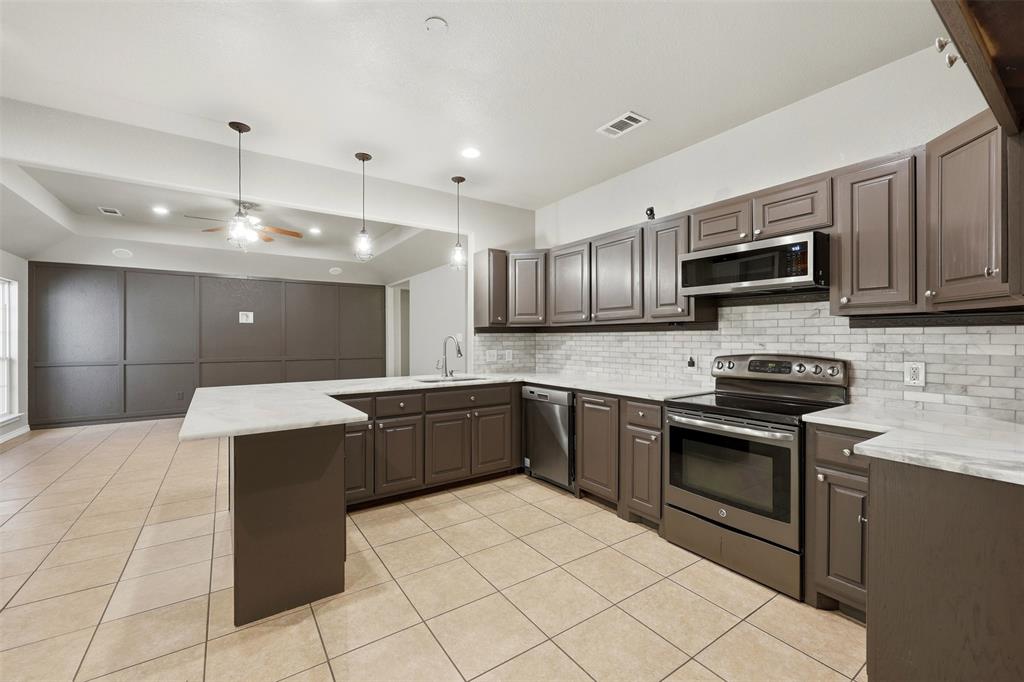 113 Mulkey Road Waxahachie, TX 75167 - Photo 8 of 39 a kitchen with a sink and stainless steel appliances