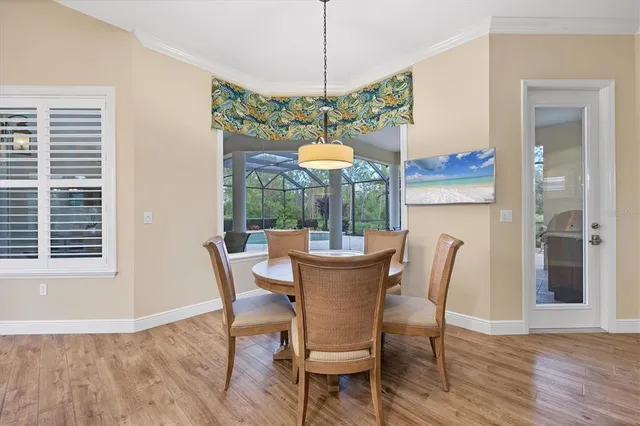 a dining room with furniture a chandelier and wooden floor