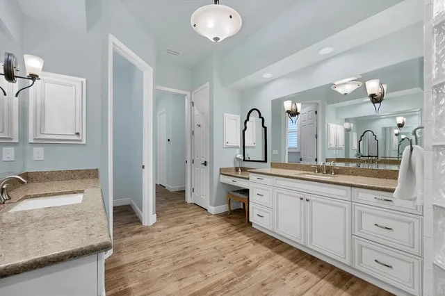a spacious bathroom with a granite countertop sink a toilet a mirror and vanity