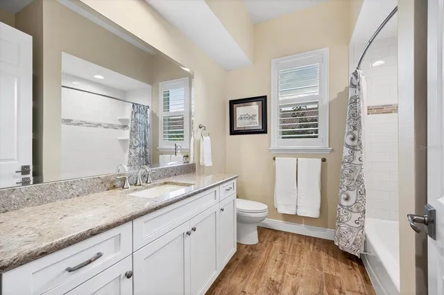a bathroom with a granite countertop sink toilet and shower