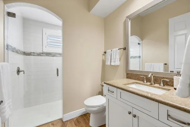 a bathroom with a granite countertop toilet sink and a mirror