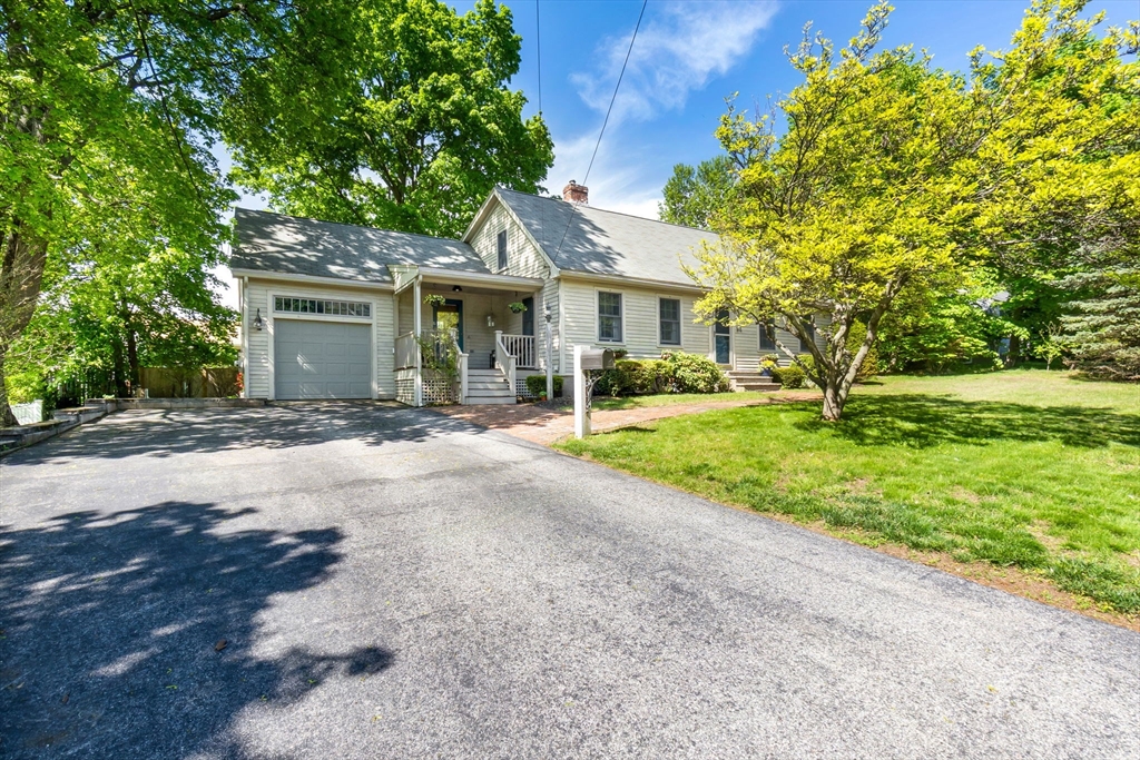 a front view of a house with a yard and potted plants