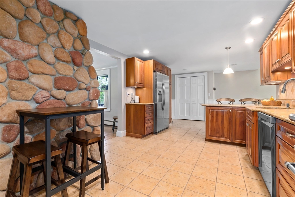 94 Conant Street Danvers, MA 01923 - Photo 11 of 36 a kitchen with stainless steel appliances kitchen island granite countertop a table and a refrigerator