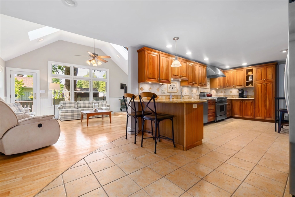 94 Conant Street Danvers, MA 01923 - Photo 8 of 36 a kitchen with stainless steel appliances kitchen island granite countertop a stove a sink a dining table and chairs with wooden floor