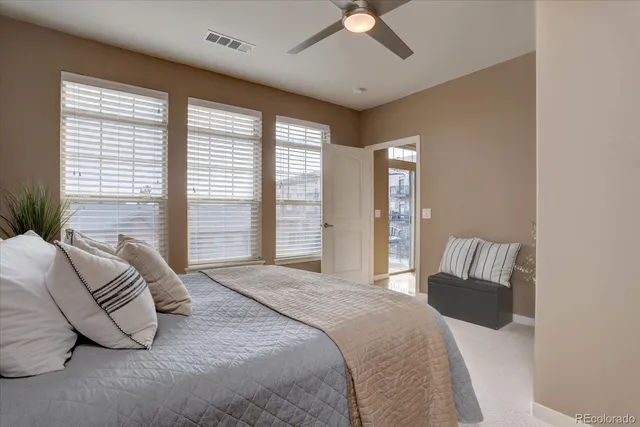 a bedroom with a large bed and a potted plant