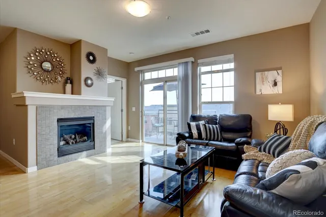 a living room with furniture a fireplace and kitchen view