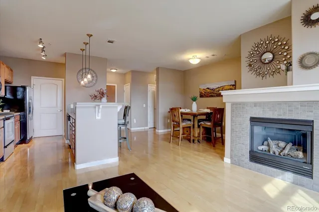 a living room with furniture kitchen view and a wooden floor