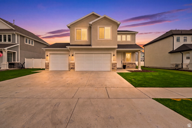 374 West Ropelato Drive Logan, UT 84321 - Photo 1 of 47 Two-story stucco exterior with stone accents, a concrete driveway, two garage doors, and a covered front porch