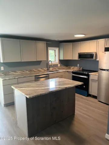 a view of a livingroom with a furniture wooden floor and chandelier