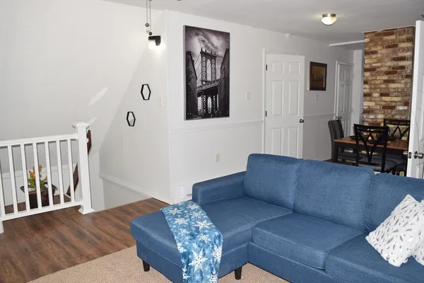a living room with furniture stairs and a window