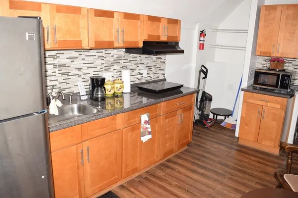 a kitchen with stainless steel appliances a refrigerator sink and wooden floor