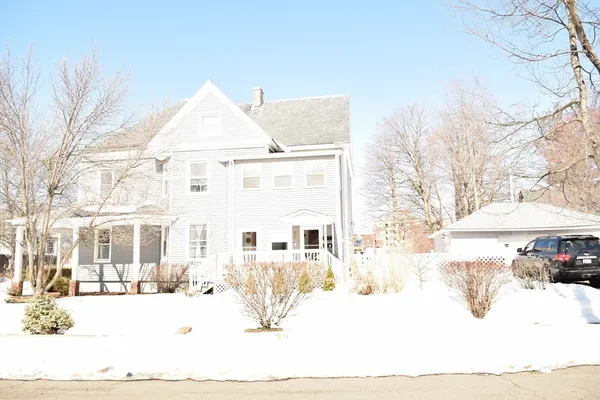a view of a white house with a yard covered in snow