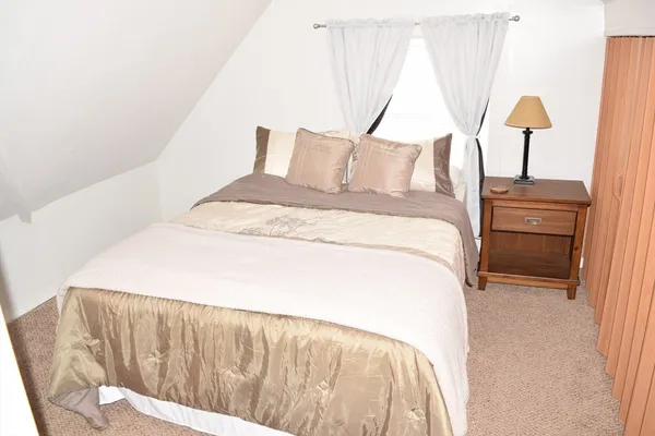 a bed sitting in a bedroom next to a window