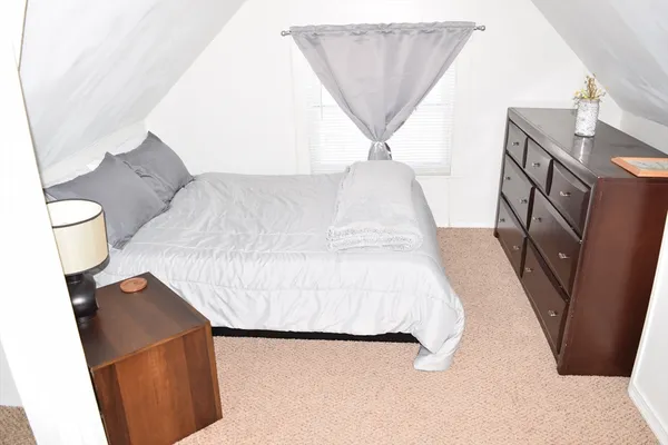 a bedroom with a bed and a rug