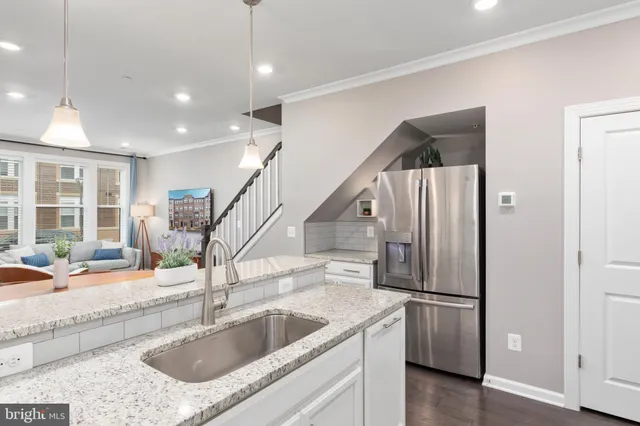 a kitchen with stainless steel appliances granite countertop a sink and a refrigerator