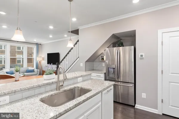 a kitchen with stainless steel appliances granite countertop a sink and a refrigerator